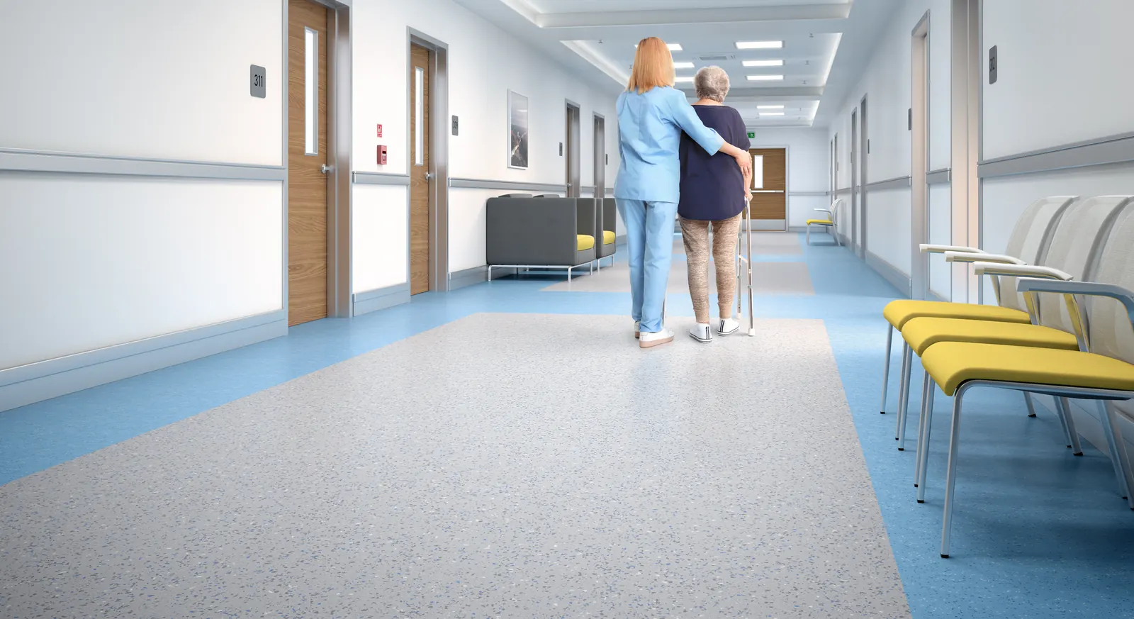 Hospital corridor floored in light grey speckled ABPure rubber sheet with a blue border